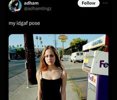 a woman in a black dress standing next to a parking meter