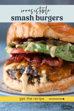 a cheeseburger with bacon, lettuce and tomato on it is sitting on a plate