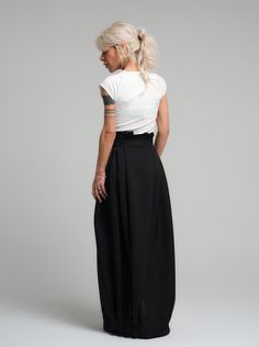 Make a bold statement with our high-waist skirt, the epitome of tailored elegance. This skirt is fashioned from premium polyester, delivering a smooth finish with a substantial feel that gracefully flows with every step. The design is accentuated by a tasteful belt that cinches the waist, while the elasticated back ensures a snug and comfortable fit. Its voluminous silhouette and sleek lines make it a versatile piece for both office wear and evening affairs. FEATURES:Includes a chic belt, elasticated back for comfort, and a high-waist cut 100% Handmade. SIZE & FIT: Fit: A relaxed fit with room to moveModel is wearing size Small or S/M View our SIZE CHART before ordering MATERIALS & CARE: Content: Polyester Care: Dry cleaning only SHIPPING: Made to order, processing time is 15 working days Chic Fitted Skirt With Wide Waistband, Black Pleated Skirt With Belt Loops For Work, Asymmetrical Skirt With Belt Loops For Work, Chic Flared Skirt With Wide Waistband, Chic Fitted Pleated Skirt With Belt Loops, Chic Draped Skirt For Work, Chic Draped Skirt For Spring Workwear, Chic Spring Draped Skirt For Workwear, Classic Black Maxi Skirt For Work