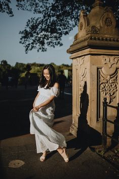 a woman in a white dress is posing for a photo