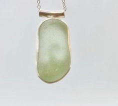 Individually handcrafted sterling silver pendant with a beautifully smooth seaglass nugget in seafoam green. The glass is sourced in Kintyre on the west coast of Scotland.  The naturally tumbled sea glass is set in a fine silver bezel and sits on a hand-sawn open backed sterling silver backplate with wave design, allowing the light to shine through. The pendant is suspended by a tube bail on a delicate sterling silver chain - please select your preferred length at checkout.  Makes an ideal gift for ladies or girls, wife or girlfriend - birthday, Christmas, anniversaries.  Other similar items available: Pendants: https://www.etsy.com/uk/shop/RockLobsterCrafts?ref=l2-shopheader-name§ion_id=24274610 Bangles & bracelets:  https://www.etsy.com/uk/shop/RockLobsterCrafts?ref=l2-shopheader-name§io Elegant Green Sea Glass Jewelry, Minimalist Green Jewelry With Recycled Glass, Green Recycled Glass Pendant Jewelry, Seafoam Sea Glass Jewelry For Gifts, Green Jewellery, Blue Sea Glass Necklace, Seaglass Necklace, Wave Pendant, Pebble Jewelry