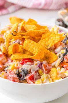 a white bowl filled with mexican salad and tortilla chips on top of it