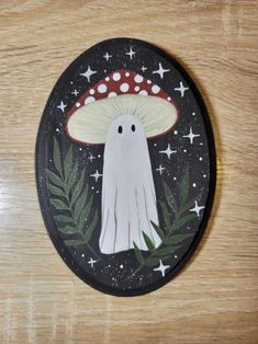 a wooden table with a painted plate on it and a white ghost in the middle