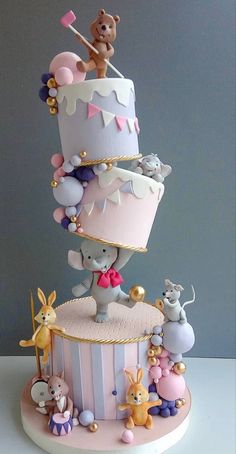 a three tiered cake decorated with animals and balloons on the top, in pastel colors