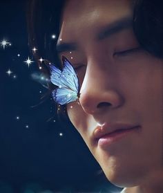 a woman with her eyes closed and a butterfly resting on her nose, in front of stars