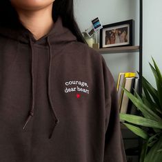 "Courage Dear, Heart ♥️" embroidered on a comfy hoodie. Everyone needs a cozy go-to hoodie to curl up in, so go for one that's soft, smooth, and stylish. It's the perfect choice for cooler evenings! * 50% pre-shrunk cotton, 50% polyester * Fabric weight: 8.0 oz/yd² (271.25 g/m²) * Air-jet spun yarn with a soft feel and reduced pilling * Double-lined hood with matching drawcord * Quarter-turned body to avoid crease down the middle * 1 × 1 athletic rib-knit cuffs and waistband with spandex * Front Hooded Hoodie With Letter Embroidery For Fall, Streetwear Hoodie With Embroidered Text, Hooded Hoodie With Embroidered Text For Streetwear, Fall Embroidered Text Hoodie Sweatshirt, Winter Black Hoodie With Embroidered Text, Hooded Sweatshirt With Embroidered Text For Fall, Hooded Fall Sweatshirt With Embroidered Text, Fall Hooded Sweatshirt With Embroidered Text, Casual Black Hoodie With Embroidered Text