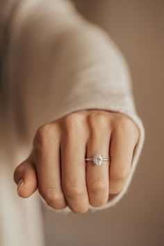 a woman's hand with a diamond ring on her finger, showing the middle finger