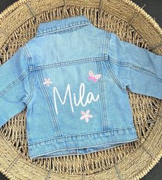 a child's jean jacket with the name mia written on it in white letters