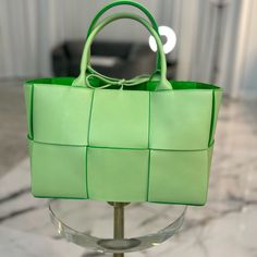 Brand New With Tag And Dustbag. Sold Out Everywhere. No Refunds Or Exchanges. This Is An Authentic Bottega Veneta Grained Calfskin Intrecciato Small Arco Tote In Pistachio And Parakeet. This Exceptional Handbag Is Crafted Of Grained Green Leather In A Maxi Weave Effect And Features Leather Top Handles. The Top Is Open To A Bright Green Suede Leather Interior. Size & Details Height: 20 Cm | 7.9" Width: 30 Cm | 11.8" Depth: 11.5 Cm | 4.5" Handle Drop: 15 Cm | 5.9" Tie Fastening Twin Top Handles De Designer Green Handheld Bag, Luxury Green Bags For Errands, Green Luxury Bag For Errands, High-end Green Bags For Shopping, High-end Green Shopping Bag, High-end Green Bags With Double Handle, High-end Green Tote Bag, Luxury Green Shopping Bag, Designer Green Bag With Handle Drop