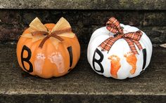 two pumpkins decorated with hand prints and bows