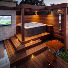 an outdoor hot tub in the middle of a wooden decked area with lights on