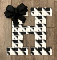 the letter h is made out of black and white plaid paper with a bow on it