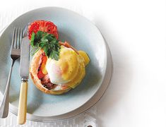 a plate with some food on it next to a fork and knife, sitting on a white table cloth