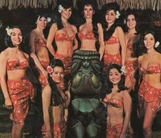 a group of women standing next to each other in bikinis and head wraps