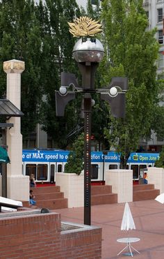 a street light on the side of a road with trees and buildings in the background