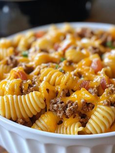 a white bowl filled with macaroni and cheese on top of a wooden table