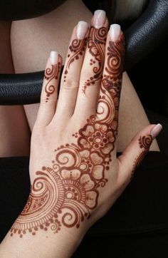 a woman's hand with henna tattoos on it