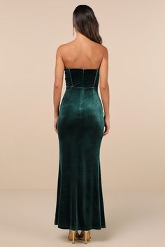 a woman wearing a green velvet dress with gold heels on her feet and back view