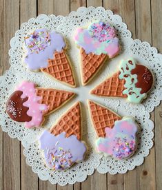 six decorated ice cream and sprinkle cookies on a doily with white lace