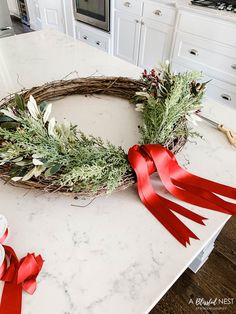 a wreath with red ribbon on top of a kitchen counter