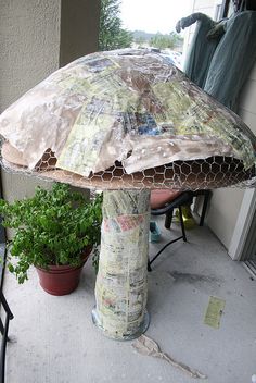 an umbrella sitting on top of a table next to a potted plant