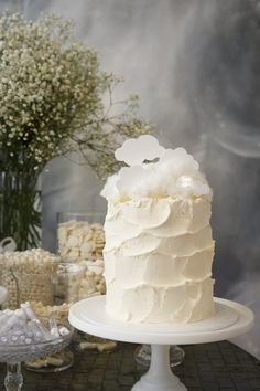 a white frosted cake sitting on top of a table