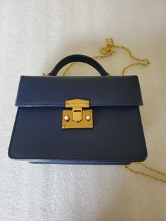 "This listing is for a Designer Bag made by \"Charles & Keith\" in a blue pebbled hard body Top Handle purse. The hardware is in a gold tone with two white faux pearl cabochon accent on the clasp. On the top is a small hard handle with two side rings for adding a chain to make it a crossbody. This purse came all the way from Delta, Colorado it was in consignment shop. I did pay up for this handbag and it appears to be in mint conditions. Please look at the photos and video for more details. The Luxury Blue Box Bag With Detachable Handle, Affordable Blue Top Handle Box Bag, Luxury Blue Pouch Satchel, Luxury Blue Square Satchel, Classic Blue Top Handle Box Bag, Classic Blue Shoulder Bag With Chain Strap, Classic Blue Rectangular Box Bag, Blue Square Bag For Formal Occasions, Blue Office Clutch Bag