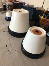 three white and black cones sitting on top of a table next to other craft supplies