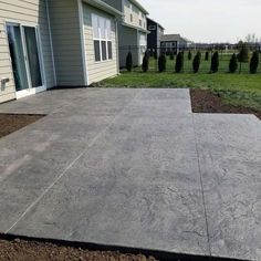 an empty concrete patio in front of a house