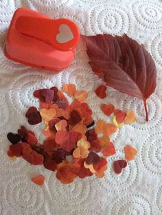 the leaves are on the table next to the orange and red heart shaped cutters