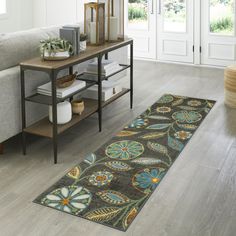 a living room area with a rug on the floor and a couch in the background