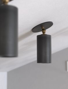 three lights are hanging from the ceiling in a room with white walls and gray ceilings