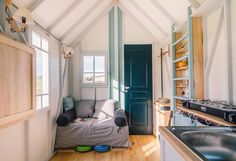 a small room with a couch, sink and stove top oven in the center of it