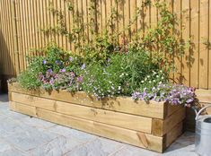 a wooden planter filled with lots of flowers