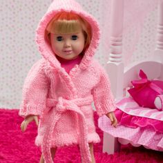 the doll is wearing a pink robe and shoes