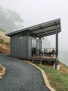 a house made out of shipping containers sitting on top of a hill