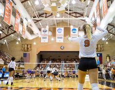 a volleyball player is getting ready to serve the ball in front of other players on the court