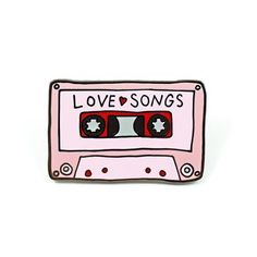 a pink and black pin with the words love songs on it's cassette tape