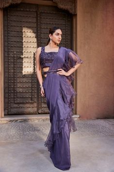 Amethyst purple sari with organza ruffle and an embroidered blouse, paired with an embroidered belt. This exquisite sari features a delicate organza ruffle and beautifully embroidered blouse, along with a stunning embroidered belt, allowing you to effortlessly elevate your style to a new level of sophistication. With its rich amethyst purple color and luxurious details, this sari exudes a sense of elegance and refinement. Perfect for any special occasion, this sari is a must-have addition to any Bollywood Style Ruffled Organza Pre-draped Saree, Elegant Purple Tissue Silk Pre-draped Saree, Elegant Purple Pre-draped Saree, Formal Organza Pre-draped Saree For Diwali, Purple Organza Pre-draped Saree For Diwali, Purple Organza Pre-draped Saree With Dupatta, Purple Floor-length Pre-draped Saree For Reception, Formal Bollywood Organza Pre-draped Saree, Purple Georgette Pre-draped Saree For Evening