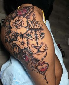 a woman with a tattoo on her thigh and arm, has a tiger surrounded by flowers