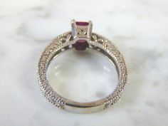 FOR SALE IS THIS LOVELY VINTAGE ESTATE 14K WHITE GOLD RING WITH AN EMERALD CUT GARNET STONE AND DIAMOND CHIPS. RING IS A SIZE 6.5 AND WEIGHS 4.9g. THERE ARE ABOUT .04cts OF DIAMONDS. THE GARNET IS ABOUT .75cts. THE RING MAKES A BEAUTIFUL GIFT FOR THAT SOMEONE SPECIAL. ANY OTHER QUESTIONS, PLEASE ASK. BE SURE TO CHECK OUT SOME OF MY OTHER GREAT ITEMS UP FOR SALE. THANK YOU Estate White Gold Rings For Gift, Estate Style White Gold Rings As Gift, Vintage Hallmarked White Gold Ruby Ring, Hallmarked Vintage White Gold Ruby Ring, Antique Diamond Cut Ruby Ring For Anniversary, Antique Ruby Ring With Diamond Cut For Anniversary, Victorian Ruby Ring With Diamond Cut For Anniversary, Anniversary Rings With Diamond-cut Ruby, Anniversary Ruby Rings With Diamond Cut