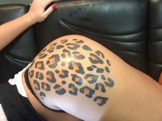 a woman's leg with a tattoo on it that has a cheetah pattern