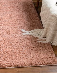 a pink rug is on the floor next to a bed