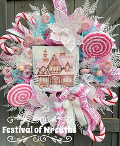 a christmas wreath with candy canes, candies and a house in the background