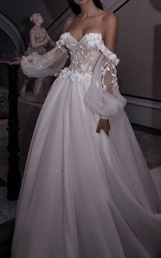 a woman in a white wedding dress standing on stairs