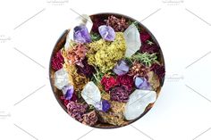 dried flowers and crystals in a bowl on a white background, top view with copy space