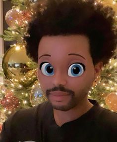 a man with big blue eyes standing in front of a christmas tree