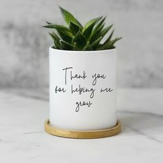 a potted plant sitting on top of a table with a thank you for helping me grow written on it