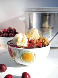 a bowl filled with ice cream and cherries next to an instant pressure cooker