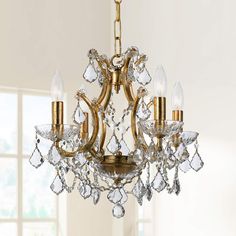 a gold chandelier with crystal drops hanging from it